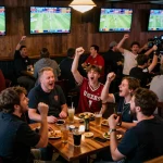 TẢI KU88 for an exciting sports betting experience at a lively venue, fans celebrating wins.